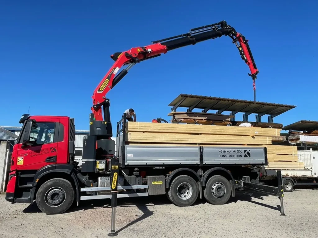 Camion grue Forez Bois Construction livrant du bois de charpente